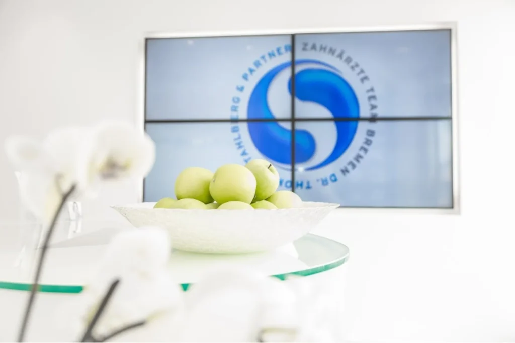 Modern gestalteter Empfangstisch mit prominentem Praxislogo der Zahnarztpraxis im Ostertor Bremen